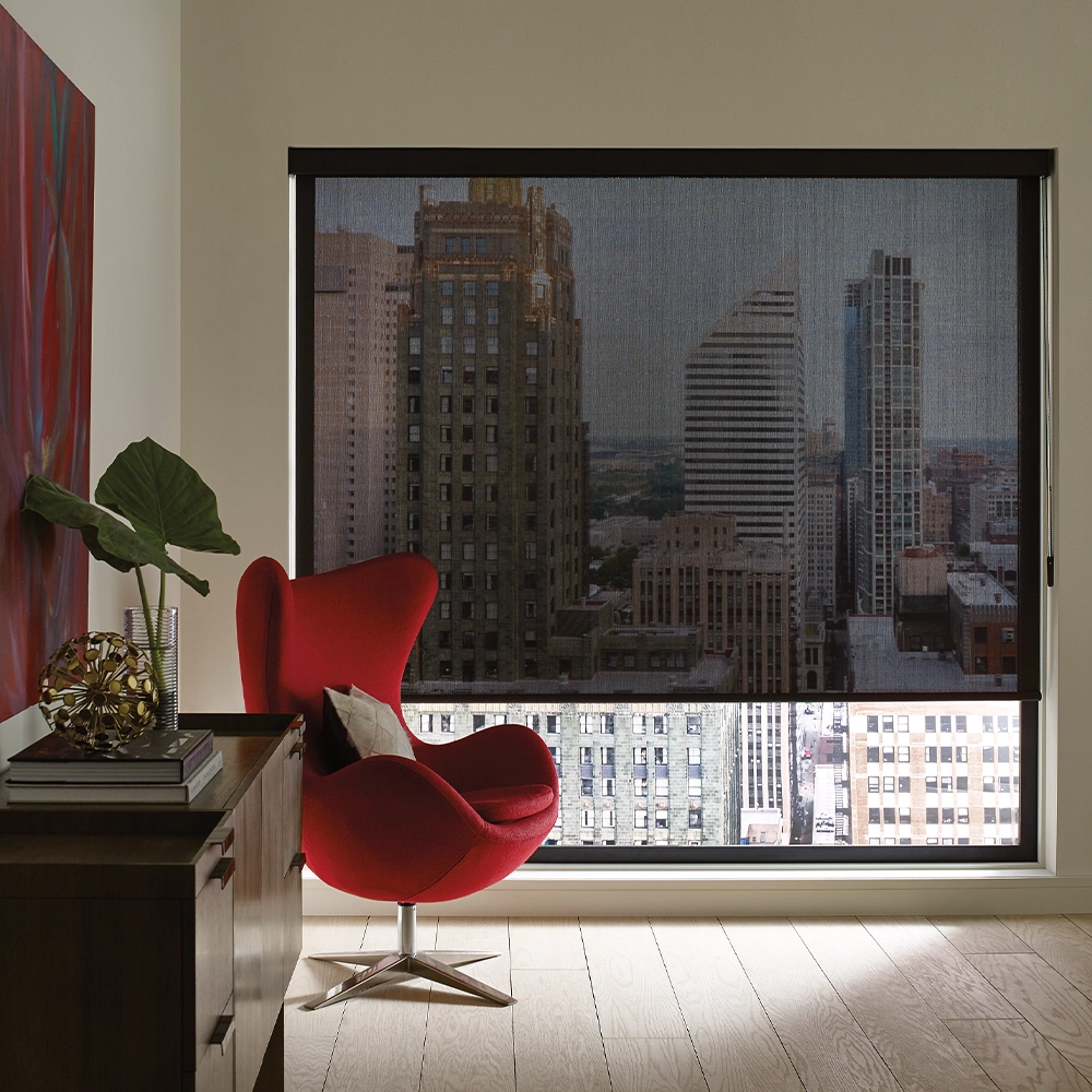 Room with red chair and black sun shades half open